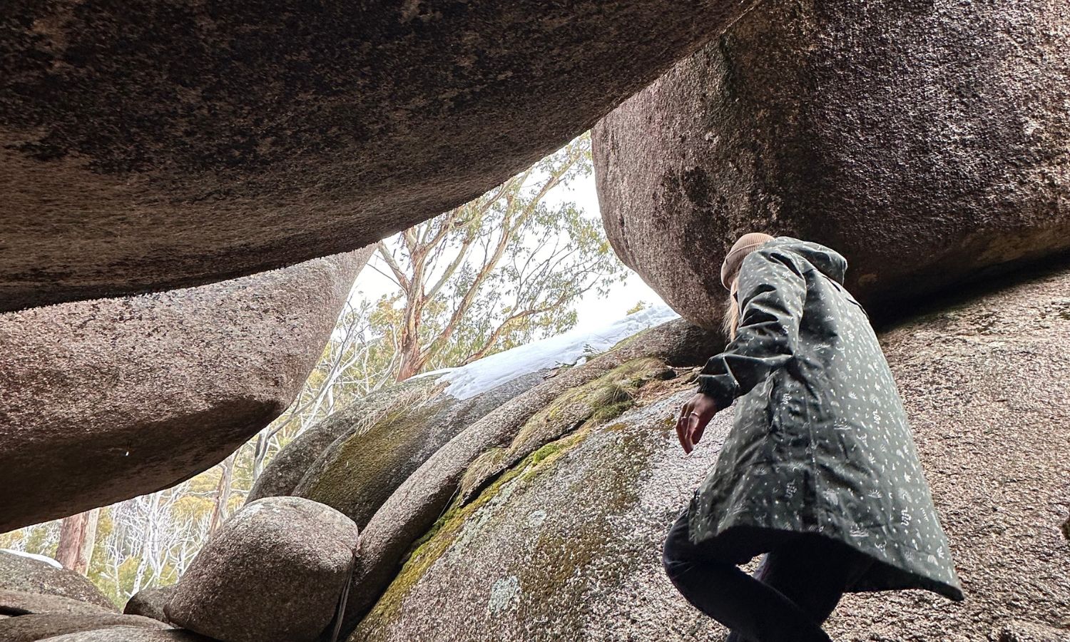 Woman wearing an Amble waterproof jacket walking among rocks